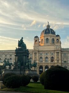 Elegant view of the Vienna Museum under a dramatic sky during golden hour.