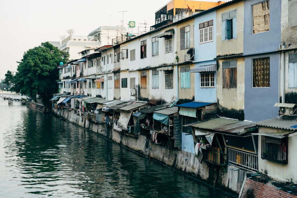 Vibrant houses along a canal in Bangkok, capturing urban life and waterfront architecture.