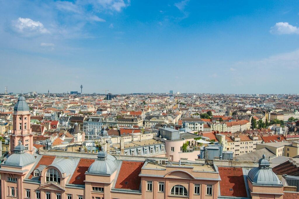 Explore Vienna's charming cityscape with this panoramic view of historic architecture and lively urban life under a clear sky.