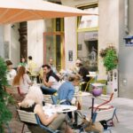 a group of people sitting at a table outside a restaurant