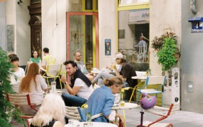 a group of people sitting at a table outside a restaurant