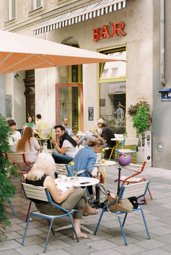 a group of people sitting at a table outside a restaurant