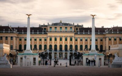 Majestic view of Schonbrunn Palace in Vienna, Austria, during sunset with people exploring the iconic landmark.