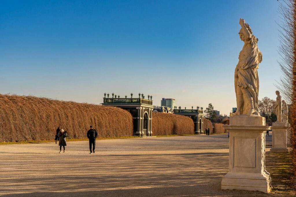 Statues and visitors in the serene gardens of Schönbrunn Palace, Vienna.