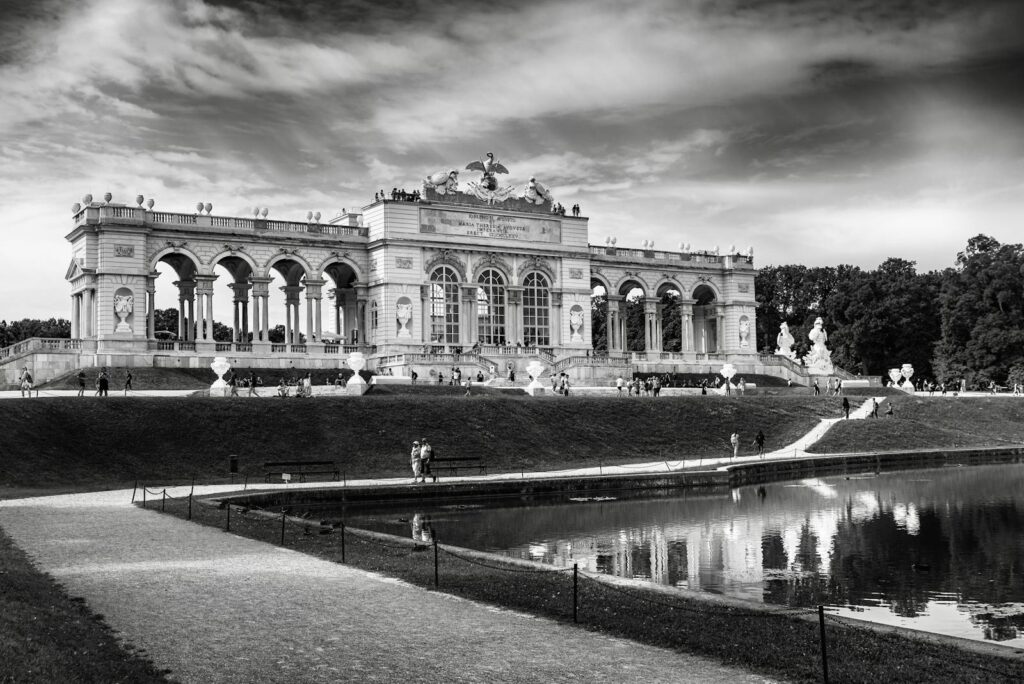 Black and white image of the Gloriette at Schönbrunn Palace, Vienna, reflecting classical architecture.